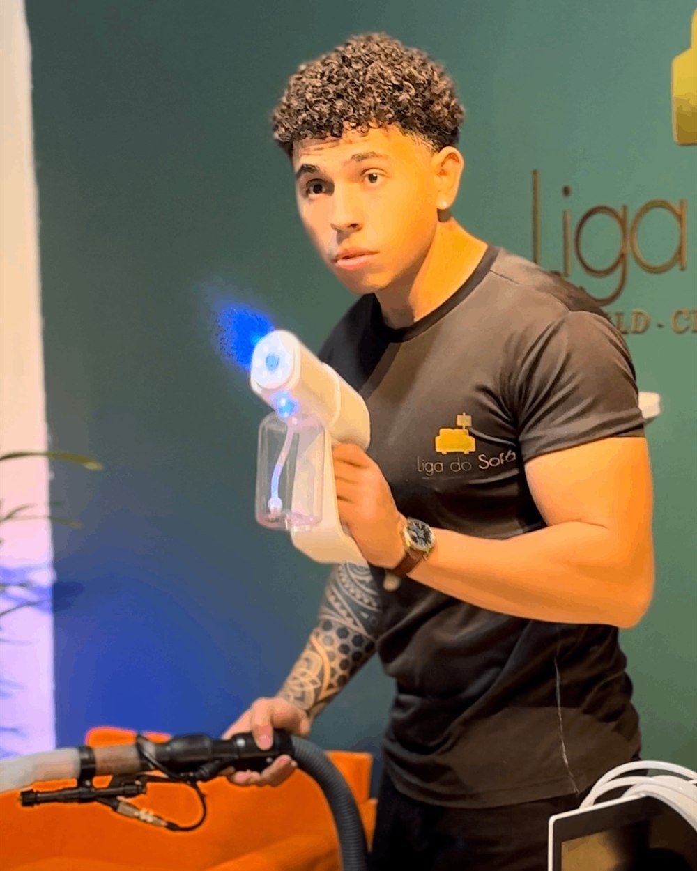 KEEL segurando a pistola de higienização no estúdio da Liga do Sofá